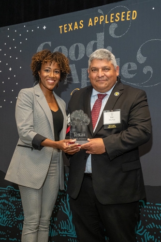 Texas Appleseed Board Member Laranda Walker presents Eric Muñoz, a partner at Akin, with Texas Appleseed’s Pro Bono Leadership Award honoring Akin on November 15, 2023.