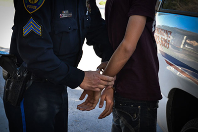 Sergeant Patrick Gabbert, for the Brownsville Independent School District, handcuffs a student from Gladys Porter High School who hasn't been attending class for a month, on Friday, Feb. 1, 2013. (AP Photo/The Brownsville Herald, Christian Rodriguez)